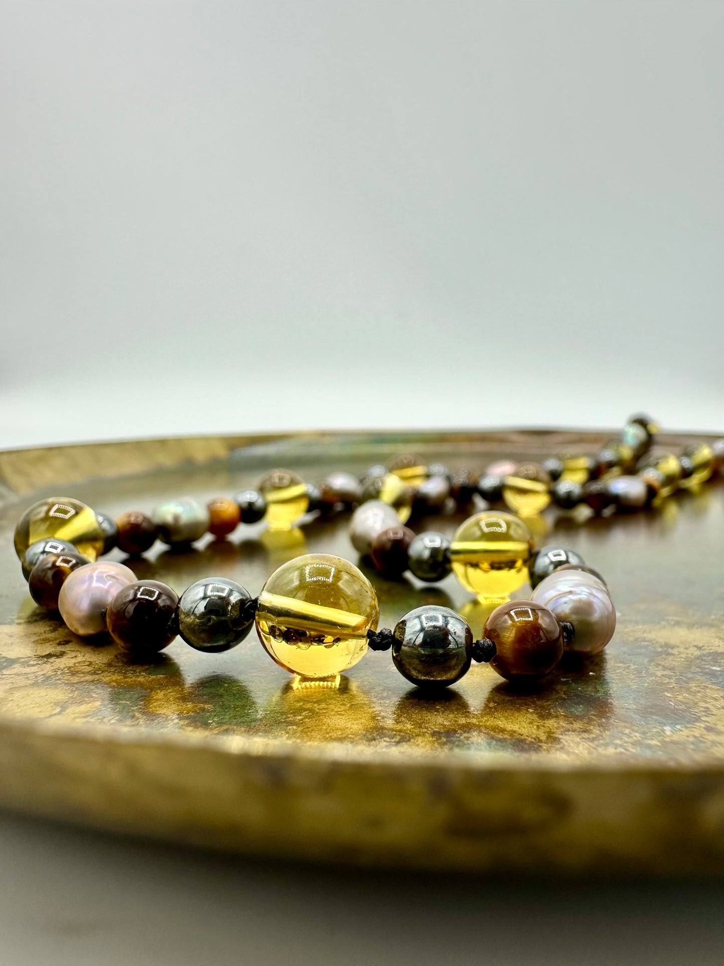 MALA CON EMATITE, OCCHIO DI TIGRE, PERLE D’ACQUA DOLCE GRIGIE E TOPAZIO GIALLO