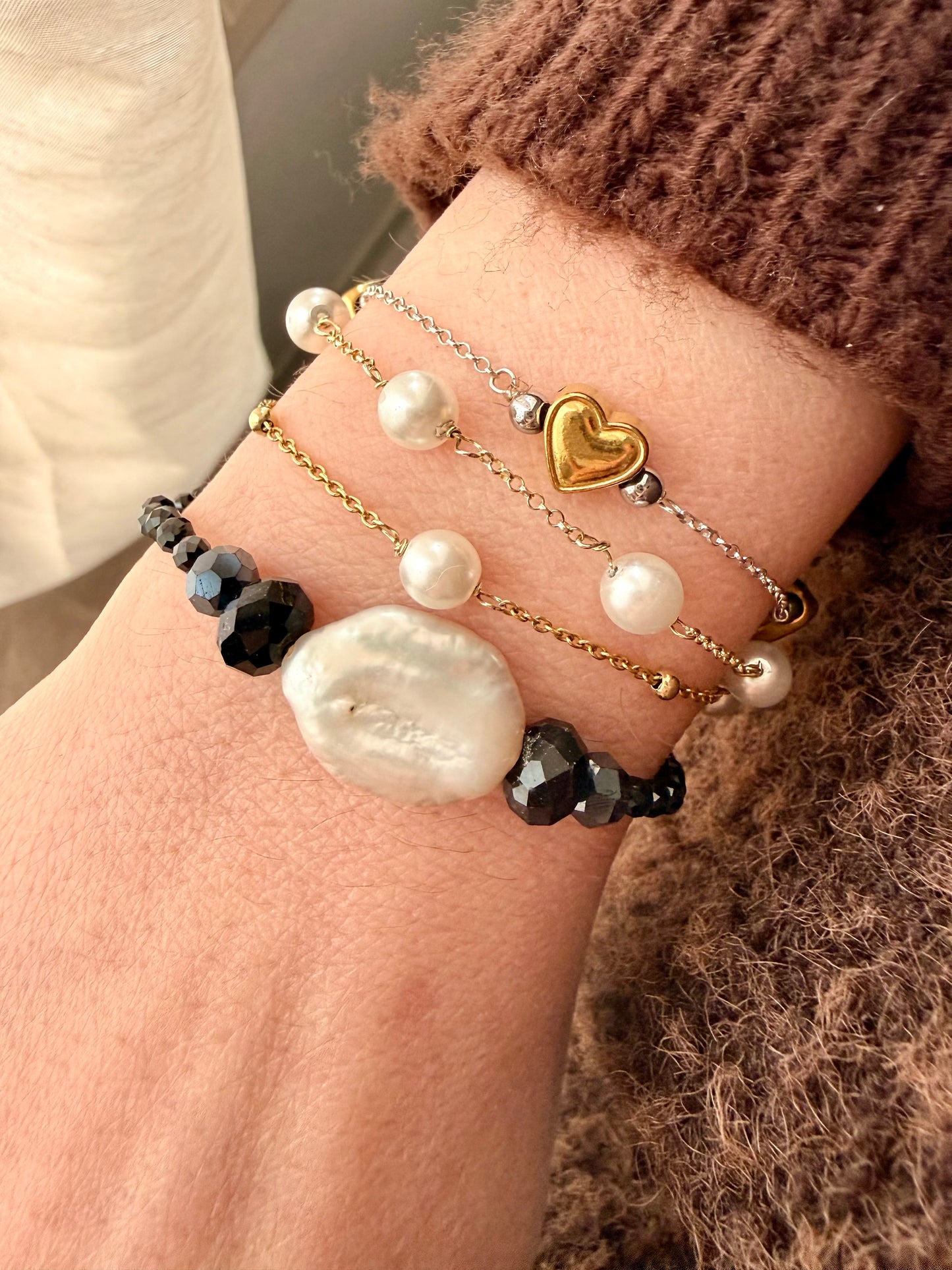 BRACCIALE ELASTICO CON CRISTALLI NERI E SPINELLI CON PERLA NATURALE CENTRALE
